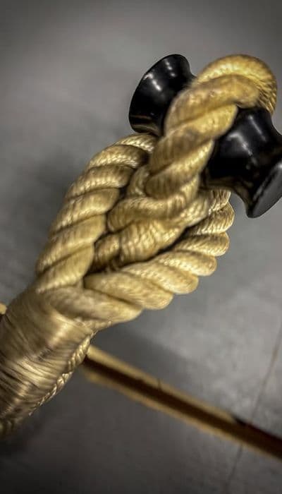 Close-up van een tokkel. Een dik touw dat rond een zwarte kikker